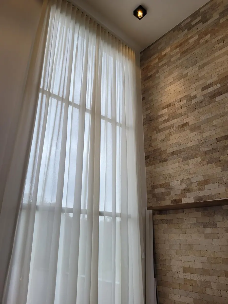 Cortina instalada no alto em ambiente de pé direito alto — suporte próximo ao teto