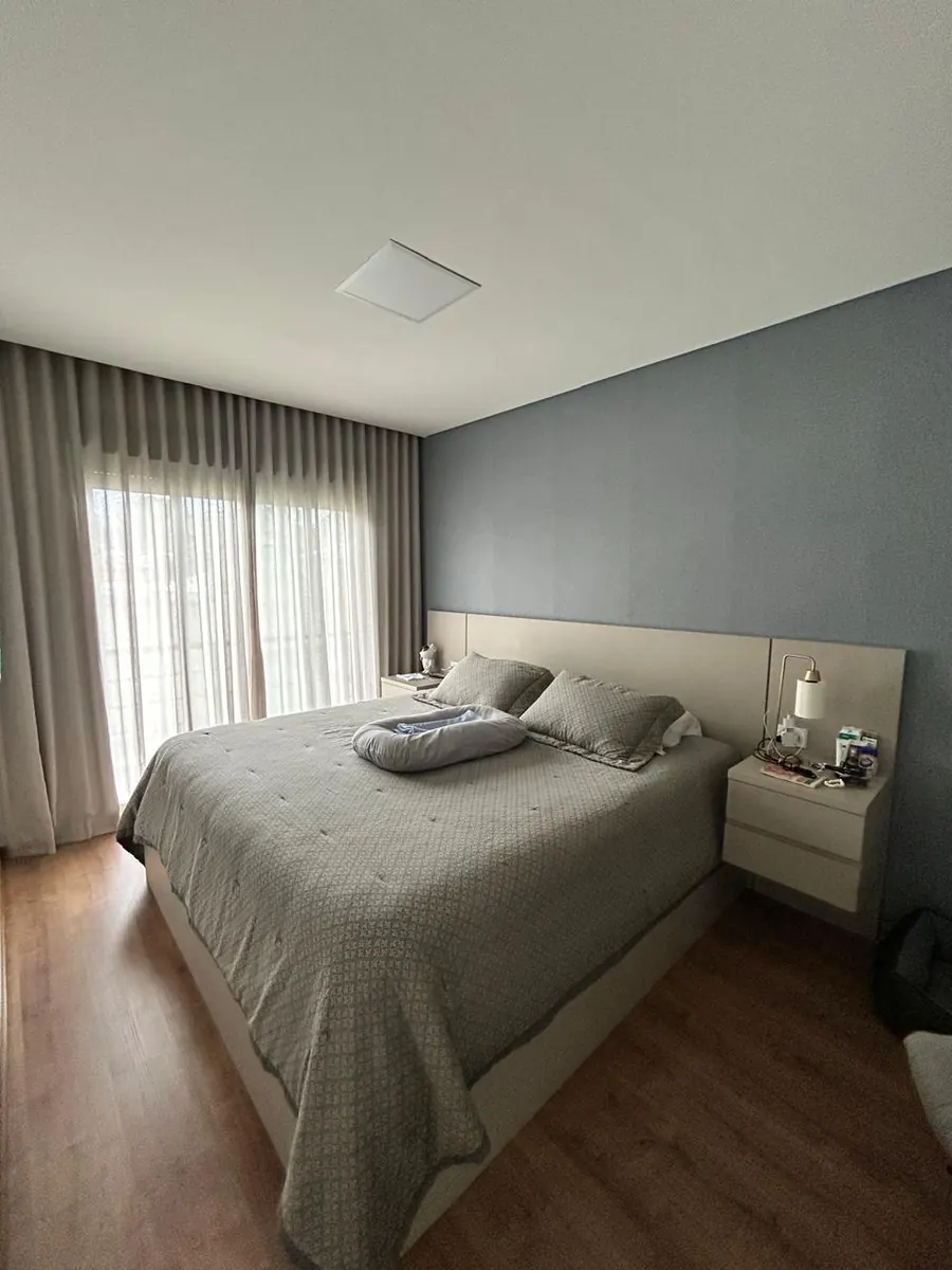 Quarto suíte com cortinas dupla escurecendo o ambiente — blackout sob medida